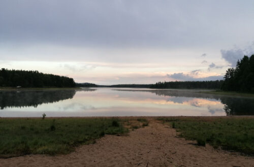 Der Abendhimmel spiegelt sich in einem See.