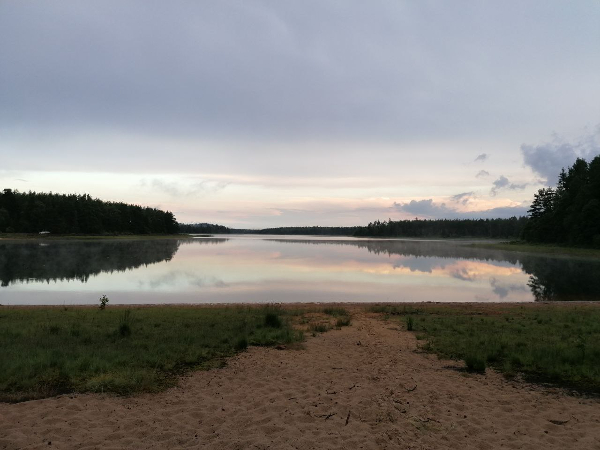 Der Abendhimmel spiegelt sich in einem See.